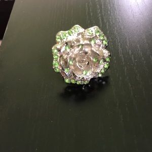 Silver flower ring with accented green gems
